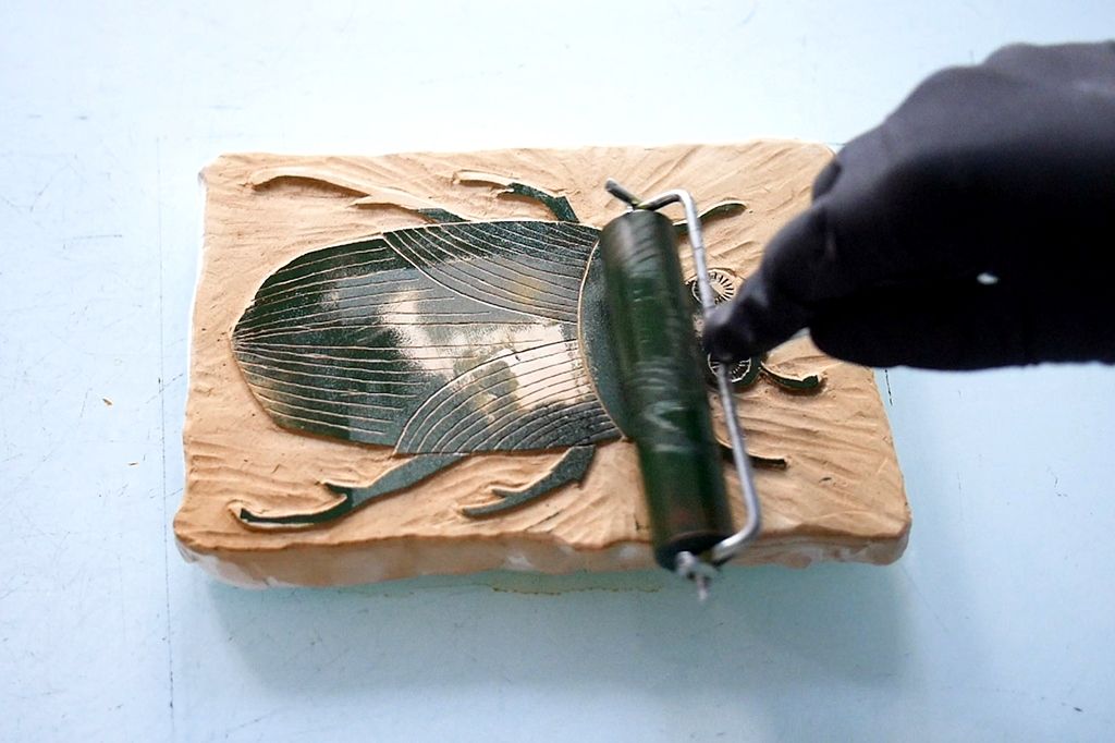 warsztaty gipsorytu, nakładanie farby na gipsową matrycę z obrazkiem chrząszcza