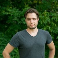 Portret młodego chłopaka w szarej koszulce na tle zielonych drzew