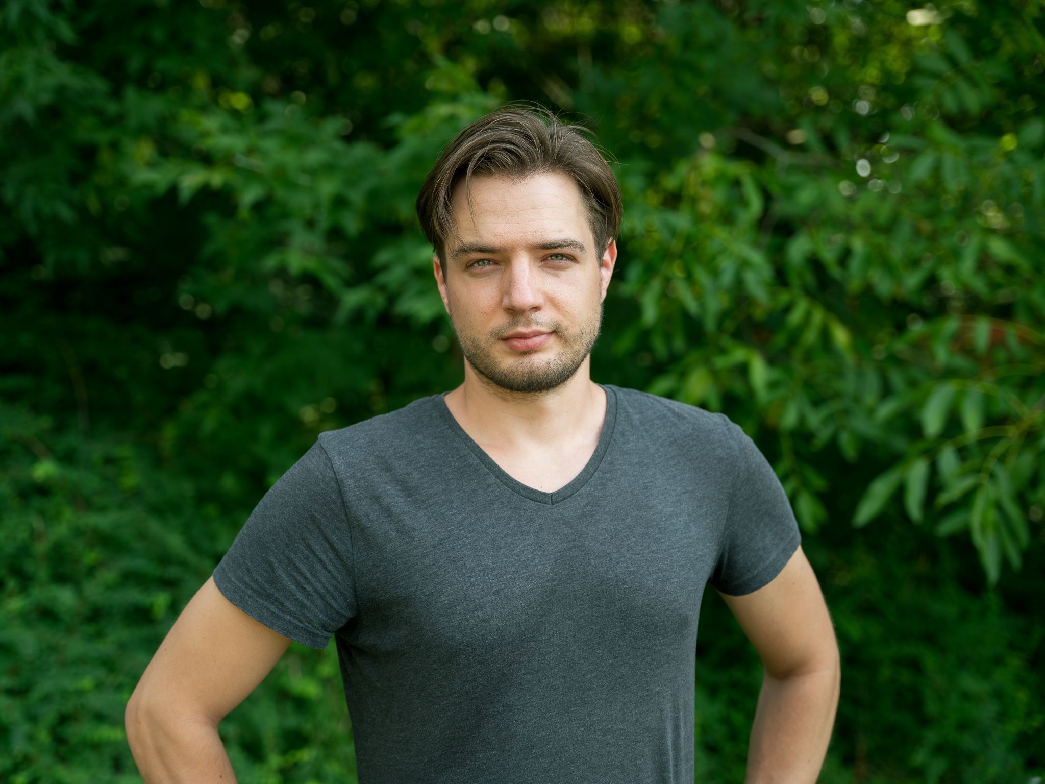 Michał Jastrzębski, portret młodego chłopaka w szarej koszulce na tle zielonych drzew